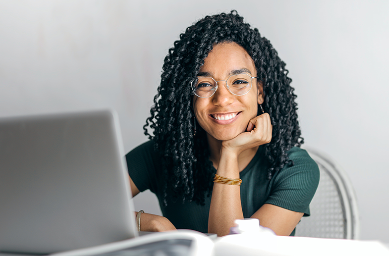 smiling student with computer and notebook